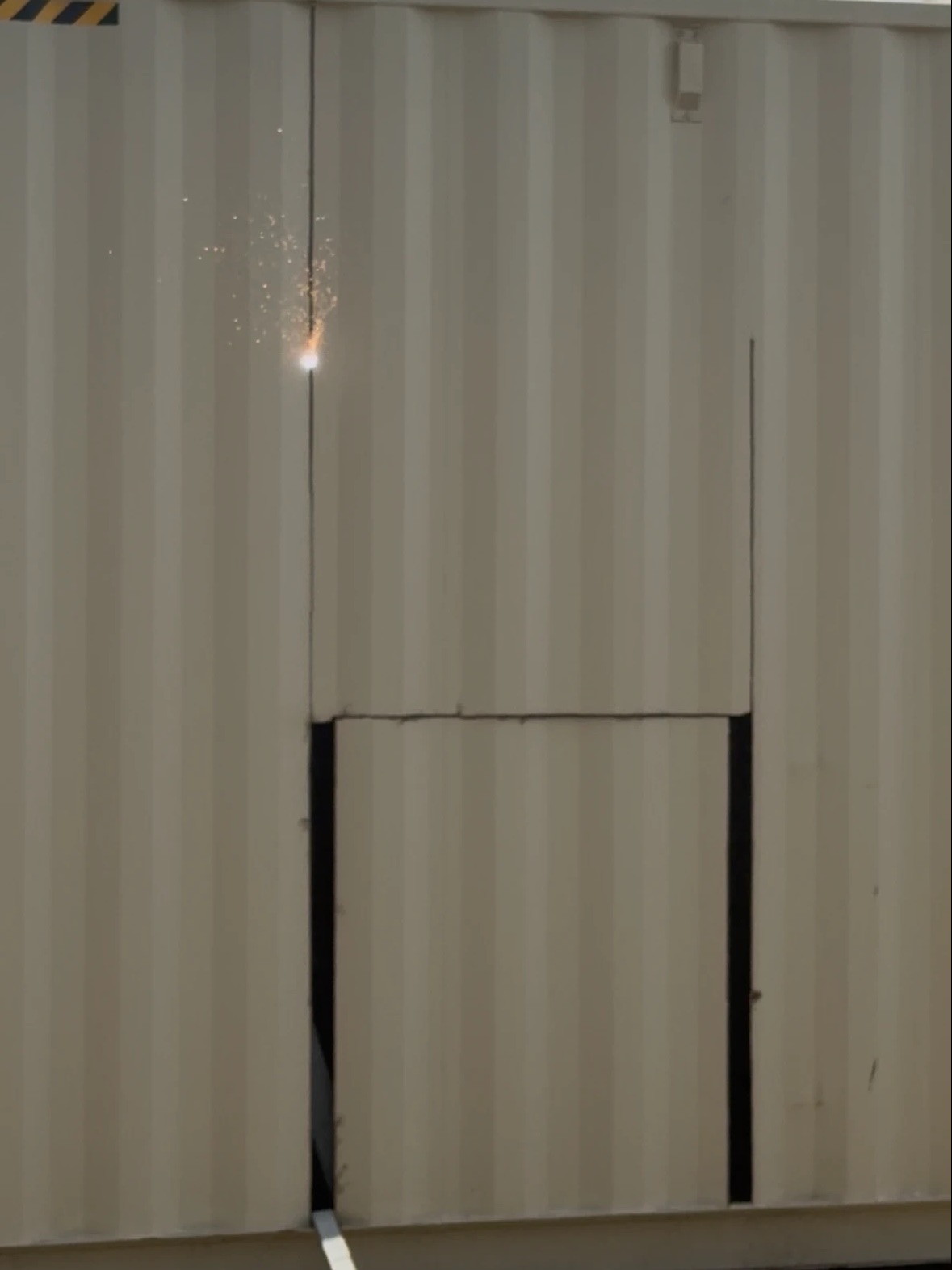 Torch cutting a door opening into a container wall