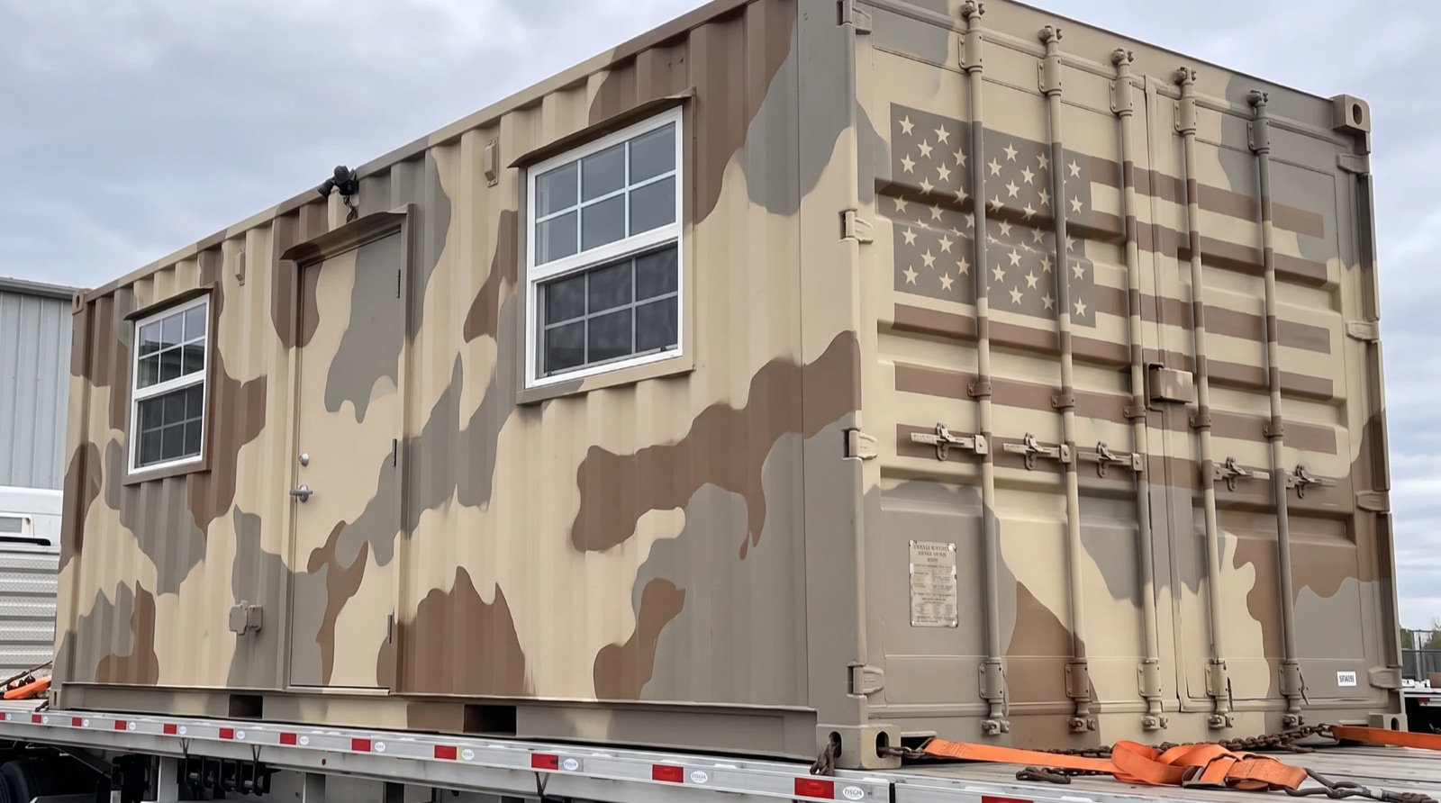 Desert-camo container office on a flatbed trailer for delivery
